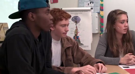 Three students in a classroom discussion